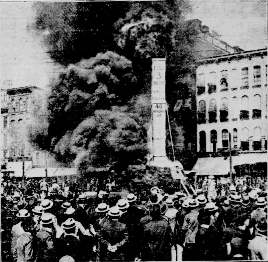 Vintage newspaper photograph of a crowd watching a street fire — period imagery recovered from public scans