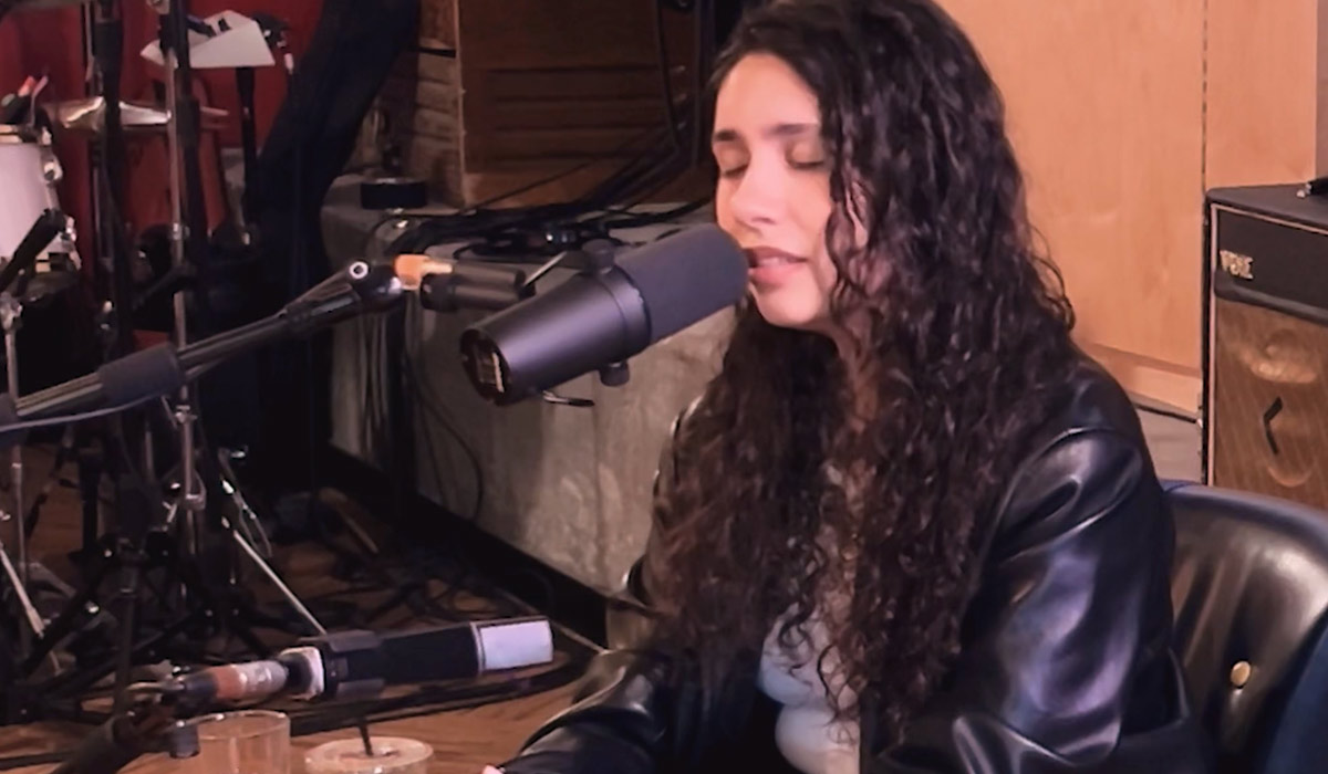 Alessia Cara singing into the studio microphone